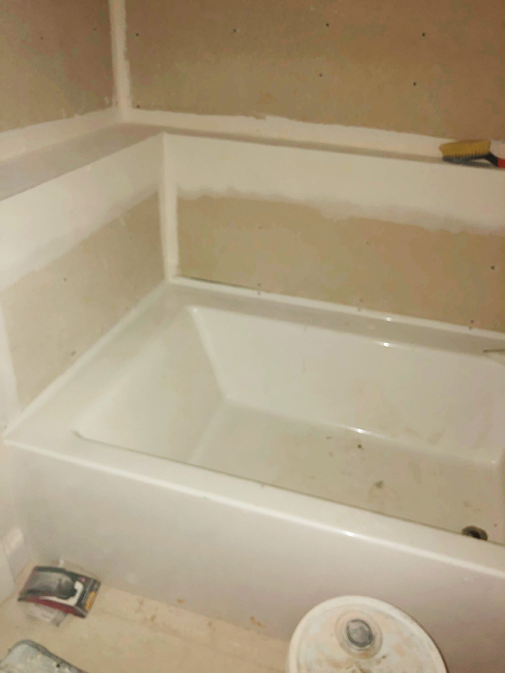 Before and after pic of giant hole in bathtub repair