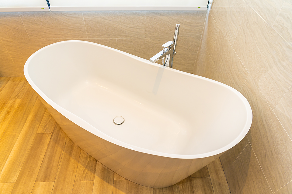 White oval bathtub in corner